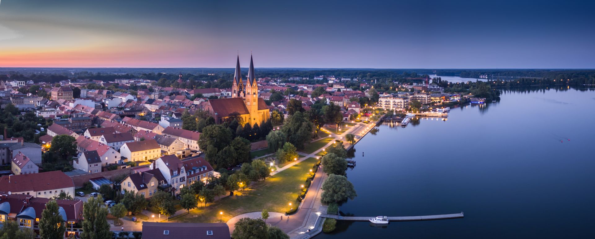Luftaufnahme von Neuruppin mit Klosterkirche und Ruppiner See bei Sonnenuntergang